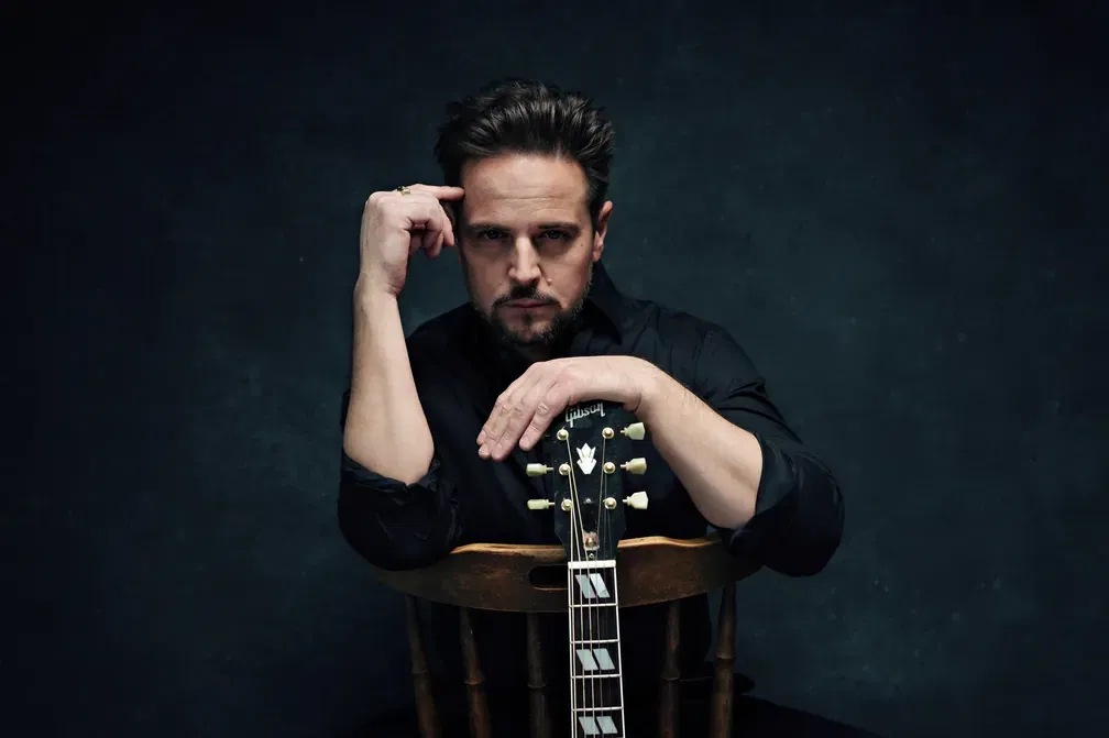 Silvestrovský galavečer 2026 Hudobník s gitarou v tmavom štúdiu - silvestrovský program